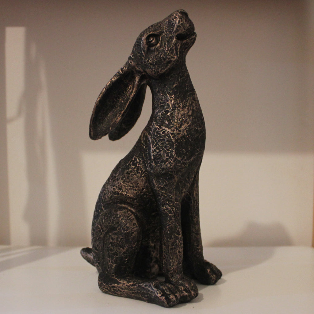 Moongazing hare sculpture on a white surface